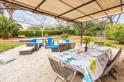 a table and chairs under a large umbrella at Villa des Rives - Welkeys in Grimaud