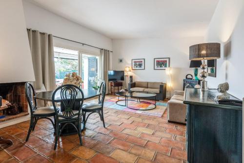 a living room with a table and chairs at Villa des Rives - Welkeys in Grimaud