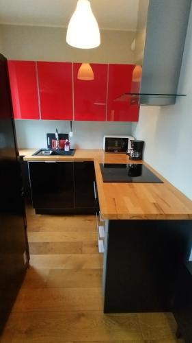 a kitchen with red cabinets and a wooden counter top at Rauma City Apartments in Rauma