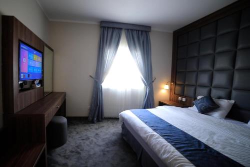 1 dormitorio con cama y ventana grande en للعائلات Suite Home at KAEC شقة بأثاث فندقي مدينة الملك عبدالله الإقتصادية, en King Abdullah Economic City