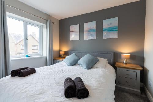 a bedroom with a white bed with pillows on it at No40Barmouth-Modern,Spacious&Hot Tub in Barmouth