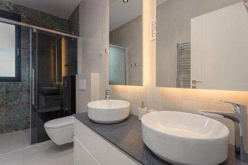 a white bathroom with a sink and a toilet at Villa Platinium in Opatija