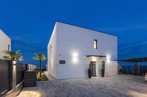a white house with a courtyard at night at Villa Platinium in Opatija