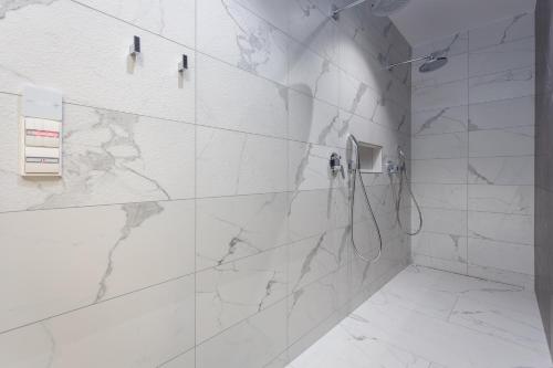 a bathroom with a shower with white marble tiles at Villa Platinium in Opatija