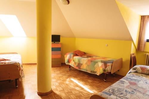 - une chambre mansardée avec 2 lits et une colonne dans l'établissement Vut RAQUEL, à Astorga