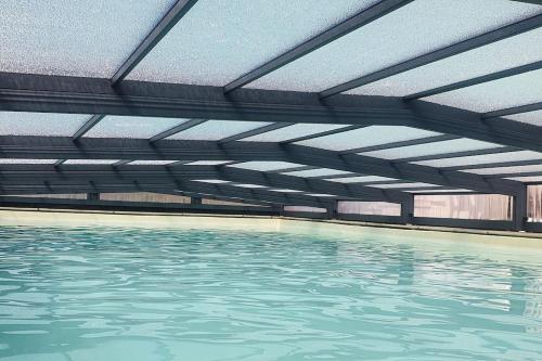 uma piscina interior com água em Longère avec Piscine Couverte Chauffée privative de Avril à Septembre em Luzillé