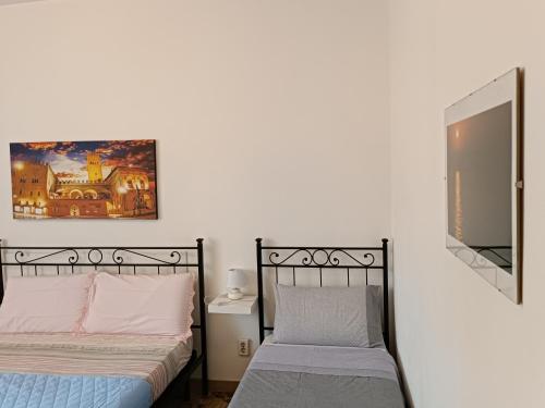 a bedroom with two beds and a mirror at Affittacamere Pratello 97 in Bologna