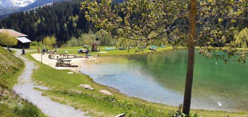 a body of water with a picnic table next to a lake at Yeti Lodge in Sedrun
