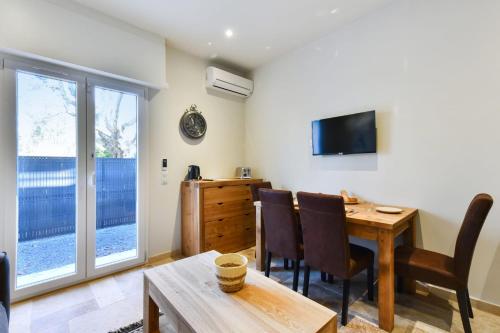 a living room with a table and chairs and a television at Comfortable flat close to the beach and Marineland Antibes - Welkeys in Antibes