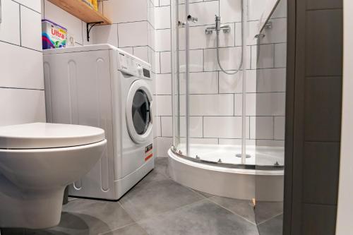 a bathroom with a toilet and a washing machine at Chałubińskiego przytulne mieszkanie przy parku, blisko dworca in Radom