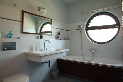 Luxury Lakefront Villa with Private Pier & Jacuzzi في بالاتونوشود: حمام مع حوض وحوض ومرآة
