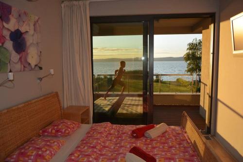 Luxury Lakefront Villa with Private Pier & Jacuzzi في بالاتونوشود: غرفة نوم مع سرير وإطلالة على المحيط