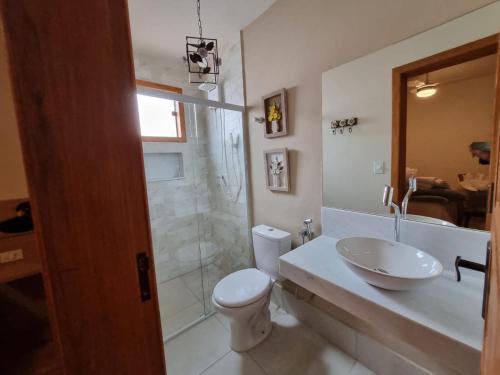 a bathroom with a toilet and a sink and a shower at Chalé das Palmeiras in Carrancas