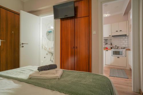 a bedroom with a bed with a television and a kitchen at Homey Edessa in Edessa