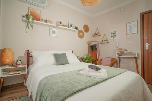 a bedroom with a white bed with a hat on it at Homey Edessa in Edessa