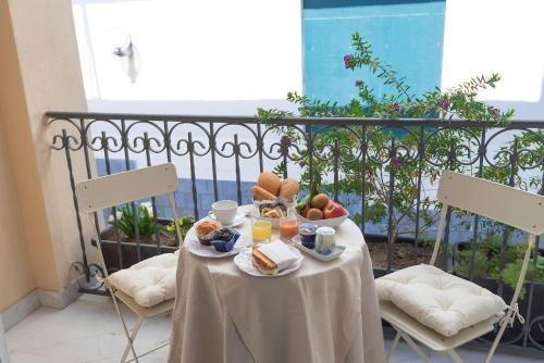 - une table avec des aliments pour le petit-déjeuner et des boissons sur un balcon dans l'établissement Hotel Fiorentina, à Naples