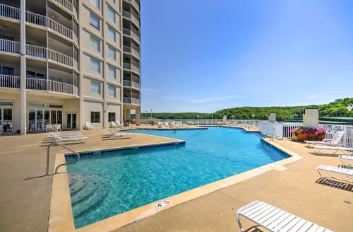 a swimming pool with lounge chairs and a hotel at Lakefront Osage Beach Condo Balcony and Pool Access in Osage Beach