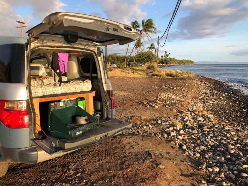 un furgone parcheggiato su una spiaggia con il retro aperto di Go Camp Maui a Ah Fong Village