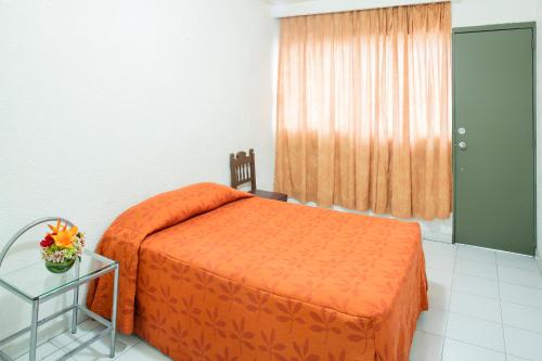 una camera con letto arancione e tavolo in vetro di Residencias Señorial a Città del Messico