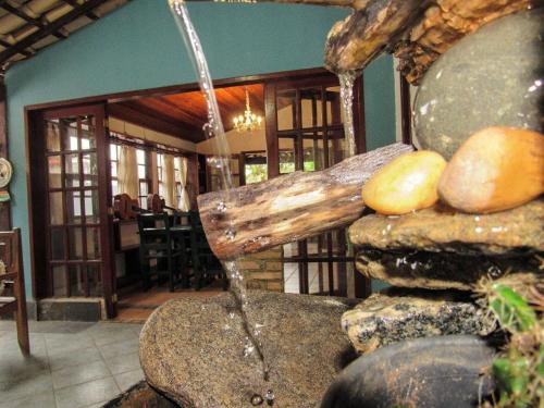 a water fountain in a room with rocks at Solo Buziano Guest House in Búzios