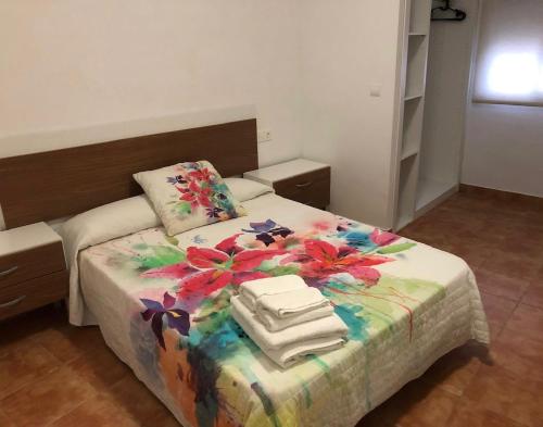 een slaapkamer met een bed met bloemen erop bij Apartamento rural cerca del centro in Caudete
