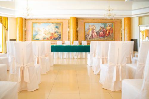 a row of white chairs and tables in a room at Hotel Villa Romana in Porto Empedocle