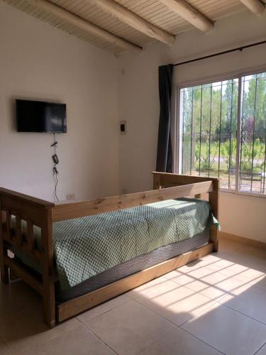 - une chambre avec un lit en bois dans une pièce dotée d'une fenêtre dans l'établissement Cabañas Vista Andes VI, à Luján de Cuyo