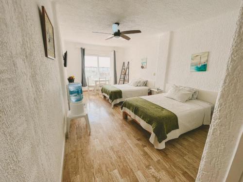 a bedroom with two beds and a ceiling fan at Cancun Plaza Condo Ocean front in Cancún