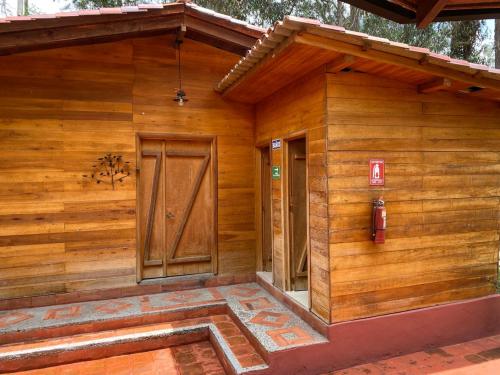a wooden house with a door on the side of it at El Castillo de Nallig in Gualaceo