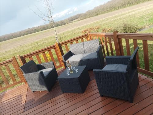a patio with two chairs and a table on a deck at Mobil home Le Galland de Dugny in Onzain