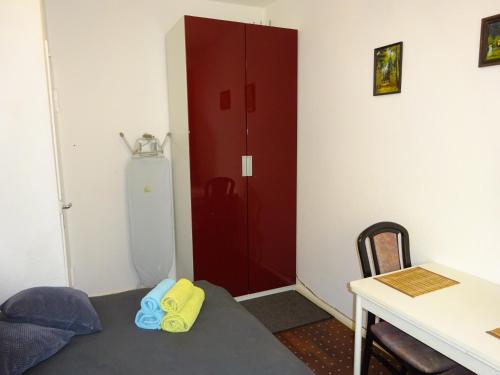 a room with a red door and a desk and a table at Wellem Unterkunft in Berlin West in Berlin