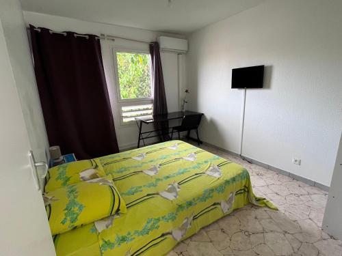 a bedroom with a yellow bed and a window at Chambre Chez l'habitant à 5mn de l'aéroport in Les Abymes