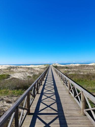 a wooden bridge leading to the beach at Pousada Brisamar Morro dos Conventos in Conventos