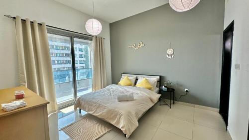 a bedroom with a bed and a large window at Himalaya Homes Lovely 1 Bedroom Apartment in Dubai