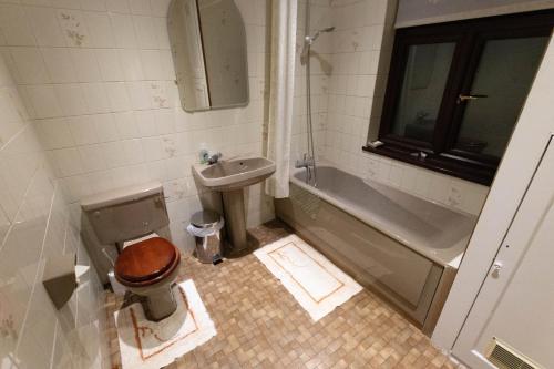 a bathroom with a toilet and a sink and a tub at Quince House in Oxford