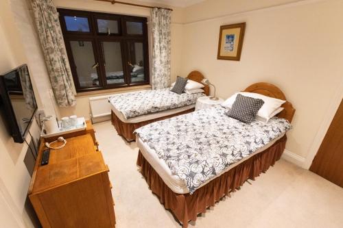 a room with two beds and a television in it at Quince House in Oxford