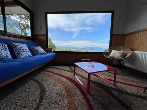 a living room with a blue couch and a table at Cabañas El Roble Lican Ray in Licán Ray