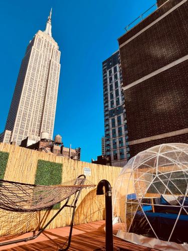 a glass dome in a city with tall buildings at Hotel and the City, Rooftop City View in New York