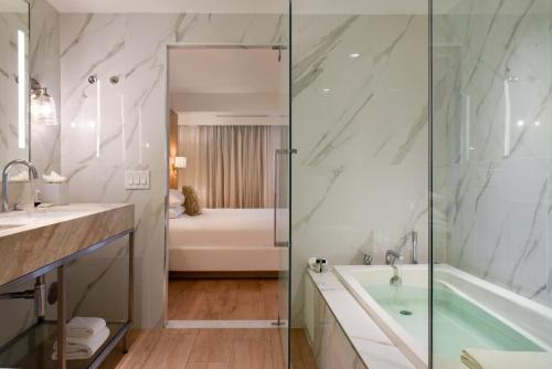 a bathroom with a shower and a tub and a sink at Hotel Ocean in Miami Beach