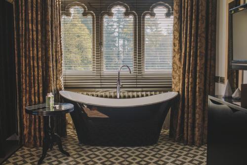 y baño con bañera y ventana. en Hampton Manor, en Hampton in Arden