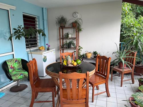 uma cozinha e sala de jantar com mesa e cadeiras em Chambre d'hôte à 5Mn de l’aéroport em Les Abymes