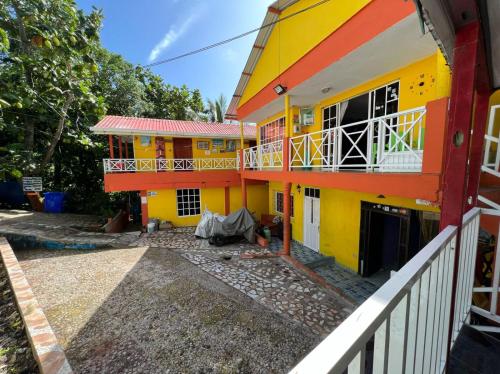 Edificio amarillo y naranja con balcón en POSADA NATIVA DERMA´S INN, en San Andrés