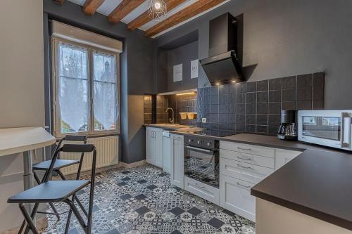 a kitchen with white cabinets and a stove top oven at L' appartement de la Paix in Romorantin