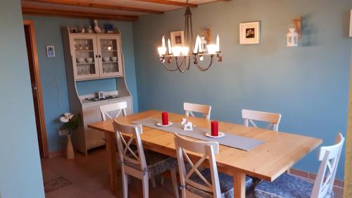 una sala da pranzo con tavolo e sedie in legno di Fehmarn Ostseeferien FW4Große Strandperle 1151 a Puttgarden