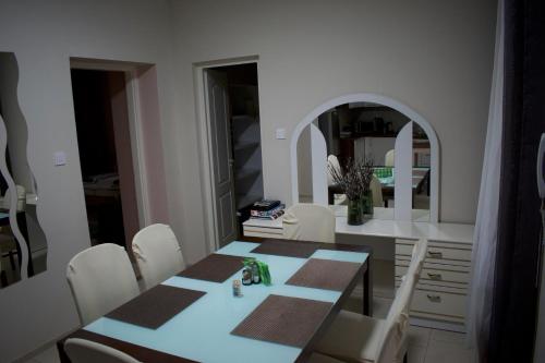 una sala da pranzo con tavolo e sedie bianche di Gerti Apartman 2 a Nyíregyháza