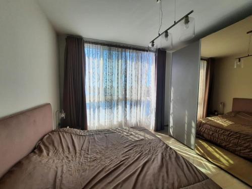 a bedroom with a bed and a large window at Cloud 7 Quality Sea Front Apartment in Marsaskala