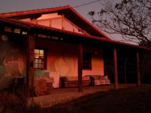 a house with a porch and a couch in front of it at Sitio Boa Fé - 300m das cachoeiras Moinho e Salomão in Carrancas