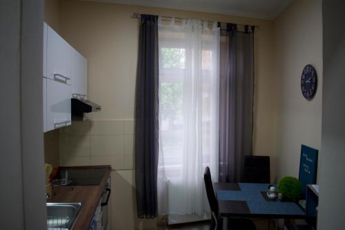 a kitchen with a window and a table with a tableablish at Gerti Apartman in Nyíregyháza