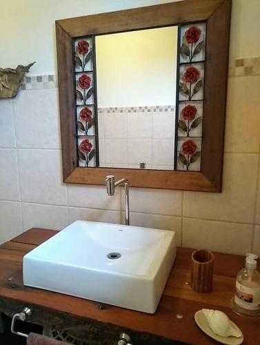 a bathroom with a white sink and a mirror at Sitio Boa Fé - 300m das cachoeiras Moinho e Salomão in Carrancas