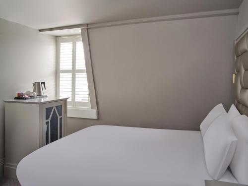 a bedroom with a white bed and a window at Henrietta House, a member of Radisson Individuals in Bath